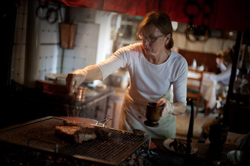 Donna alla brace mentre prepara la carne